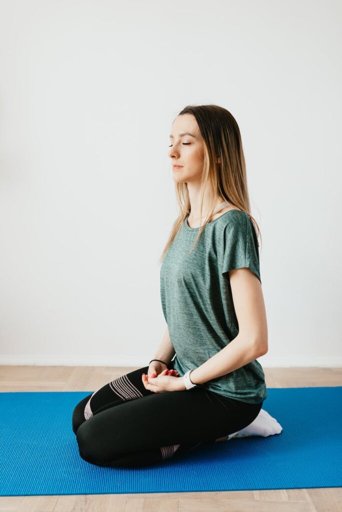 woman kneeling on a yoga mat